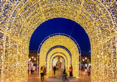 series of yellow lightening giant arches with people under them