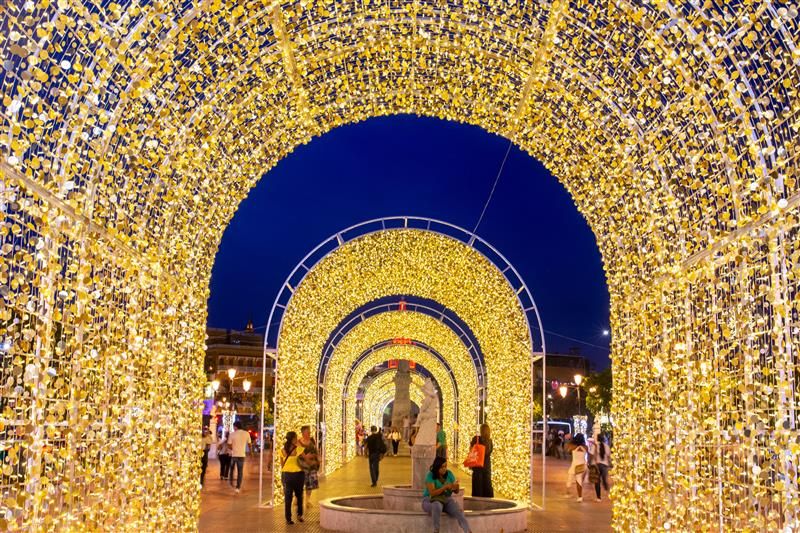 series of yellow lightening giant arches with people under them