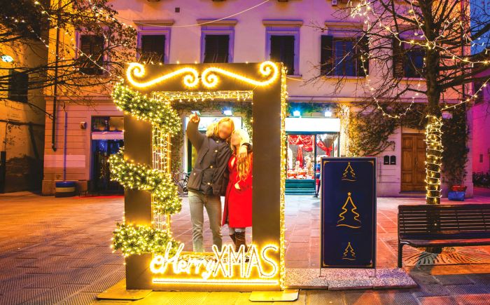 giant photoframe with Meryy Xmas writing in the bottom and a couple inside that takes a picture