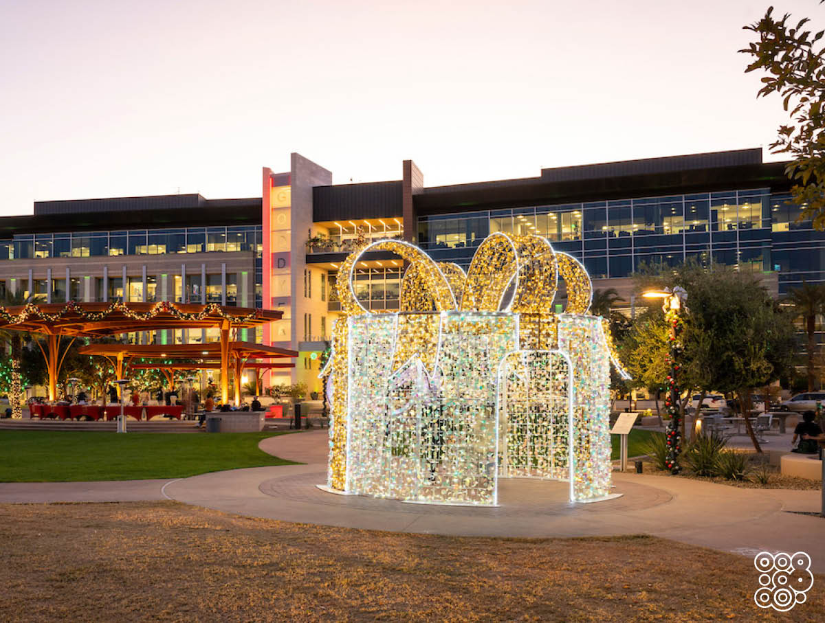 big walk through lighting christmas box in a square surrounded by buildings
