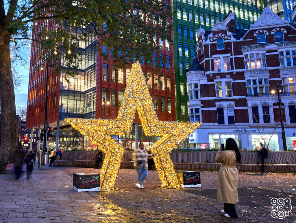 people taking a picture with a giant 3d lighting star 