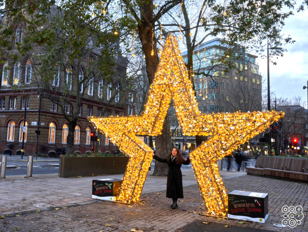girl inside a giant 3d lighting star taking a picture